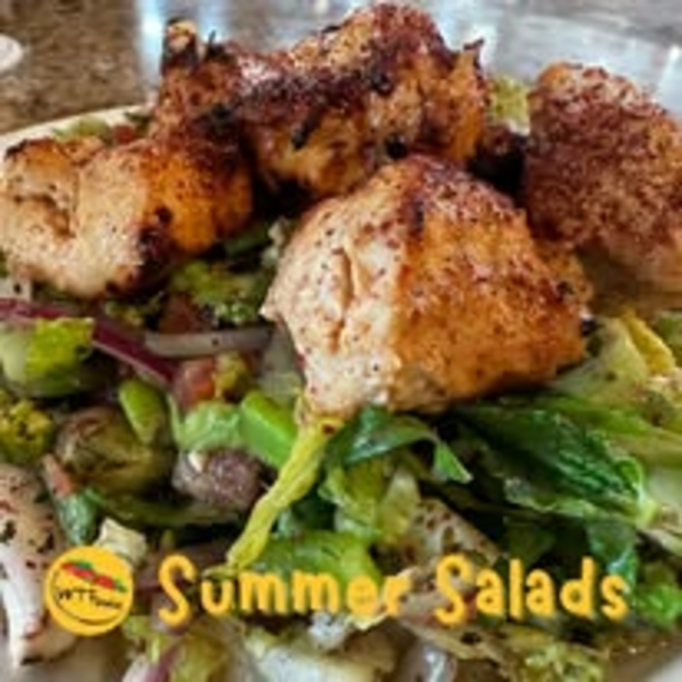 Crispy falafel balls and pita pieces served over fresh greens, with Summer Salads branding visible.