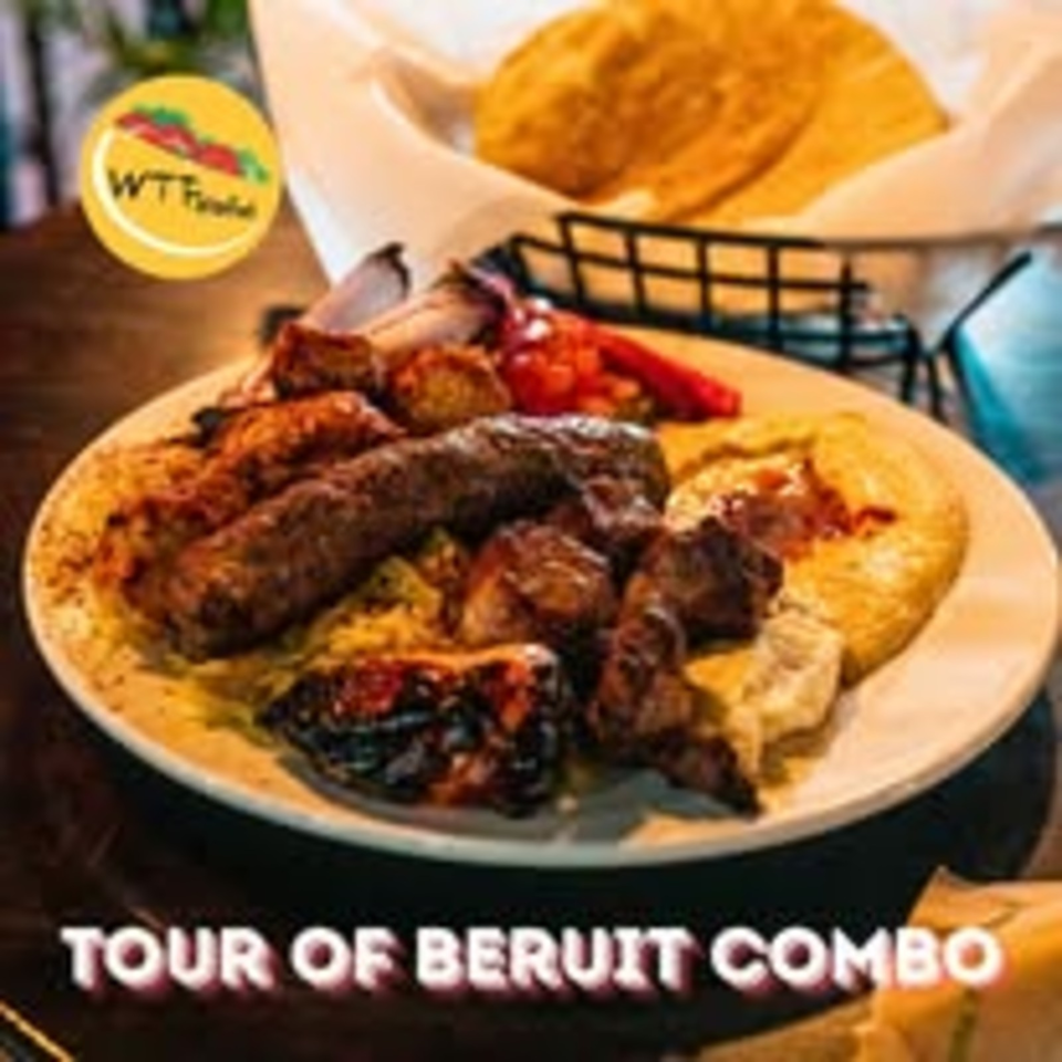 Plate of assorted grilled meats, vegetables, flatbread, and dipping sauce on a restaurant table labeled “Tour of Beirut Combo.”